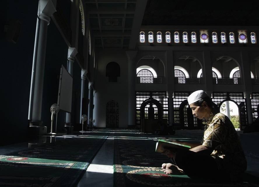 Na Indonésia, um fiel lê o Corão, livro sagrado do Islamismo, enquanto participa do Ramadã 