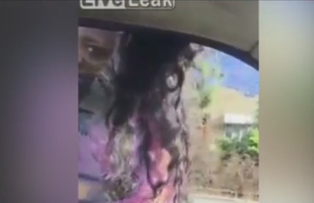 A jovem aparece com os cabelos presos na janela do lado do motorista