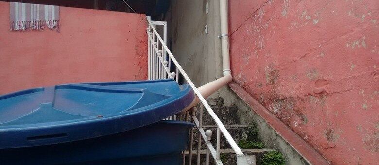 O gesseiro instalou um cano em um reservatório de água para poder reutilizar a água da chuva