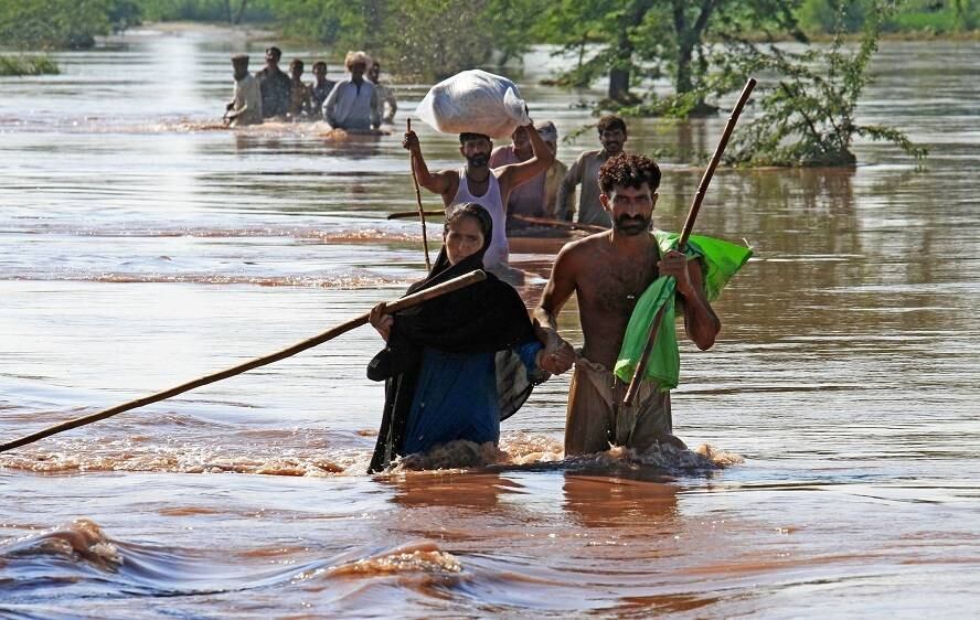 Aldeões paquistaneses fogem com alguns pertences em busca de abrigo, no nordeste de Lahore, no Paquistão. O exército e as tropas da força aérea trabalham nesta segunda-feira (8) para resgatar milhares de pessoas que estão isoladas na Caxemira, onde as inundações já causaram centenas de mortes