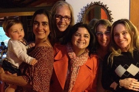 Carol Machado com a filha Tereza no colo sorrindo para o clique