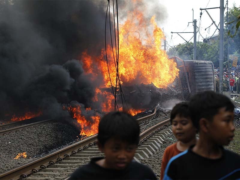 Na Indonésia, crianças andam na área onde um trem e um caminhã-trem se colidiram, matando pelo menos cinco pessoas 