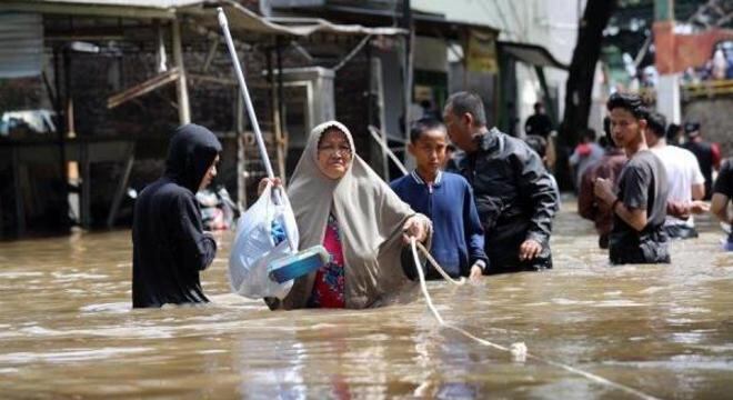 Moradores percorrem uma área inundada em Ciledug, na Indonésia