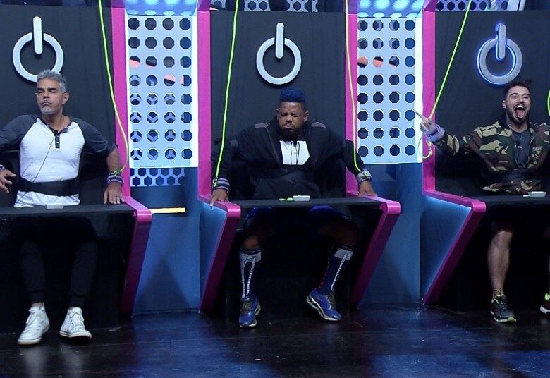 No cenário, os maridos
estão sentados lado a lado com as mãos presas a cordas, sendo controlados como
marionetes pelas suas esposas que estão na parte de cima da estrutura