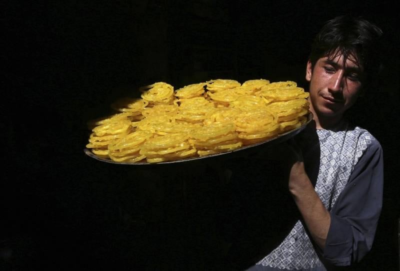 Homem carrega cesto com
doces típicos para vender durante o mês sagrado do Ramadã, em Herat, no
Afeganistão