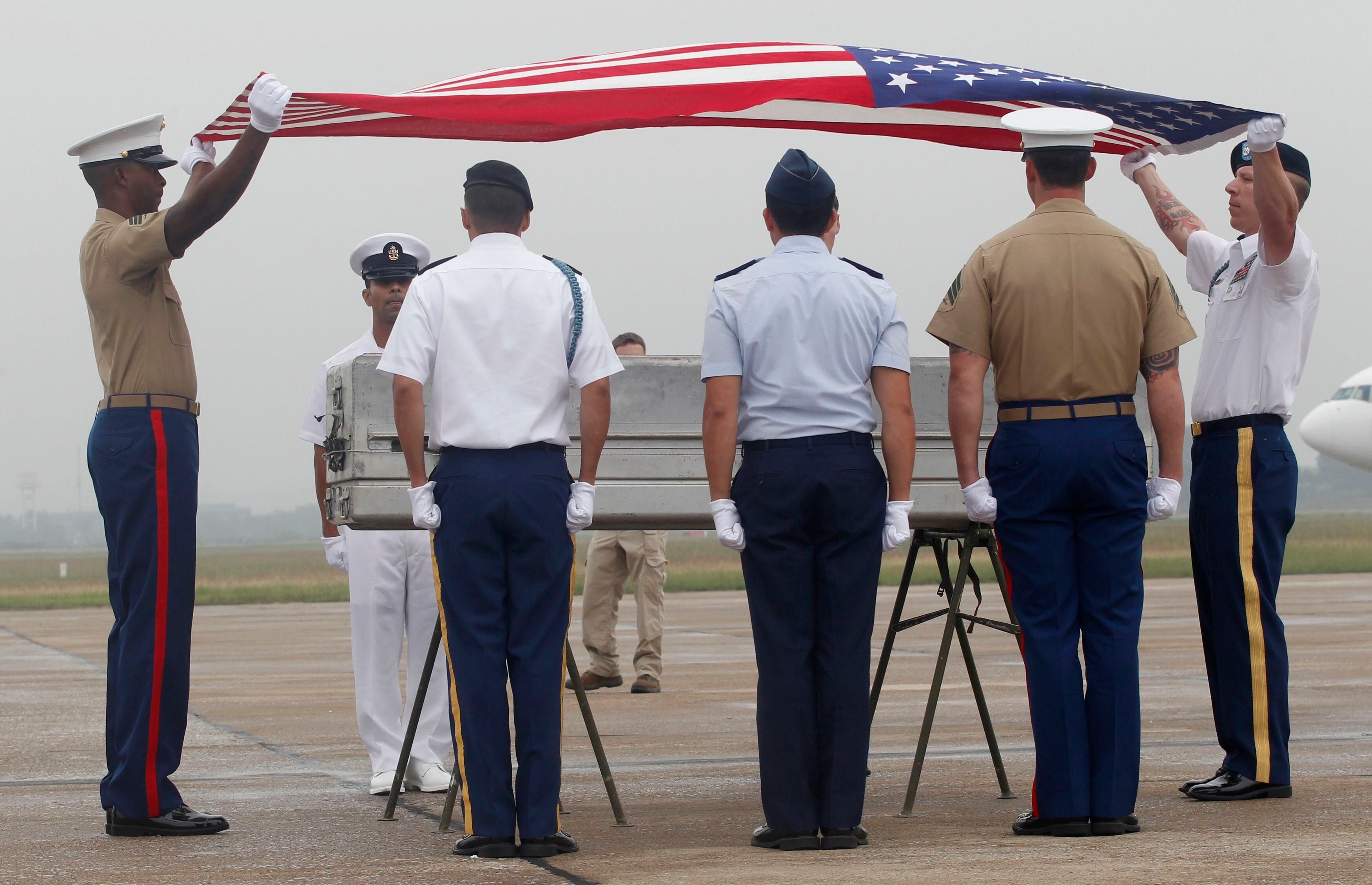 Soldados americanos dobram a bandeira dos Estados Unidos sobre caixão contendo o que acredita-se serem restos humanos de um oficial americano que sumiu em ação na Guerra do Vietnã. A cerimônia de repatriação foi realizada no aeroporto de Noi Bai, em Hanói, capital vietnamita. Ainda há 1.661 americanos desaparecidos de guerra, 1.282 deles no Vietnã.