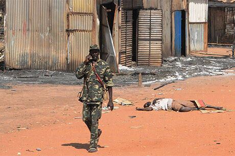 Soldo do Exército para a Libertação do Sudão do Sul caminha pelo corpo de um civil em Bentiu