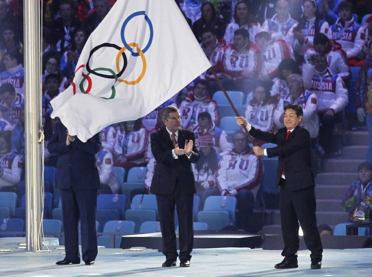 Lee Sok-ra, prefeito de Pyeongchang, cidade sul-coreana que sediará os jogos de 2014 agita a bandeira dos jogos olímpicos