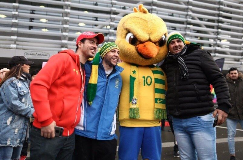 Canarinho, mascote oficial da seleção, com torcedores antes da partida