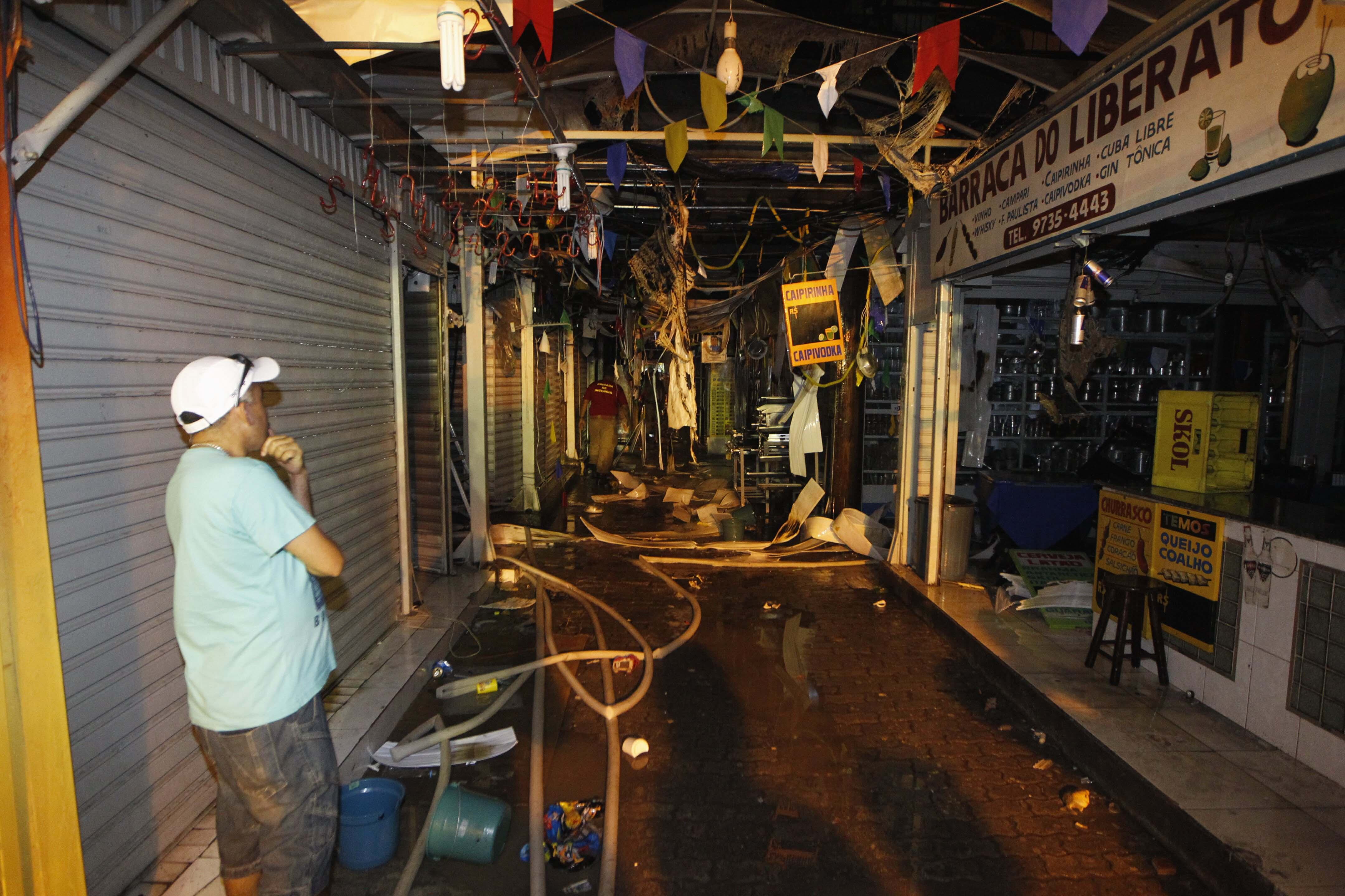 Um trabalhador do local observa o cenário após o incêndio. A principal hipótese do acidente é um curto-circuito em uma das lojas