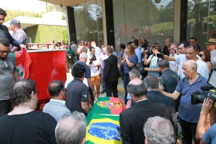 O caixão, com as bandeiras do Brasil e Portugal, foi carregado por familiares, famosos e amigos, entre eles, os cantores Ronnie Von e Naim