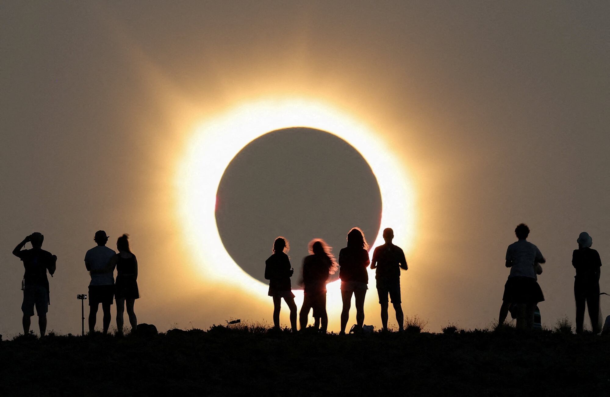 Eclipse solar total com pessoas observando o fenômeno