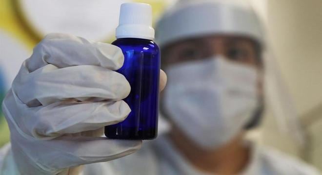 Mulher segura frasco onde envasam produto da cannabis medicinal