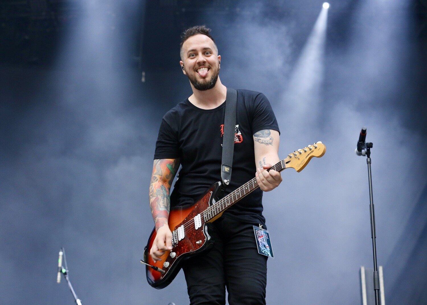 O guitarrista e baixista Niper Boaventura sorri para os fotógrafos