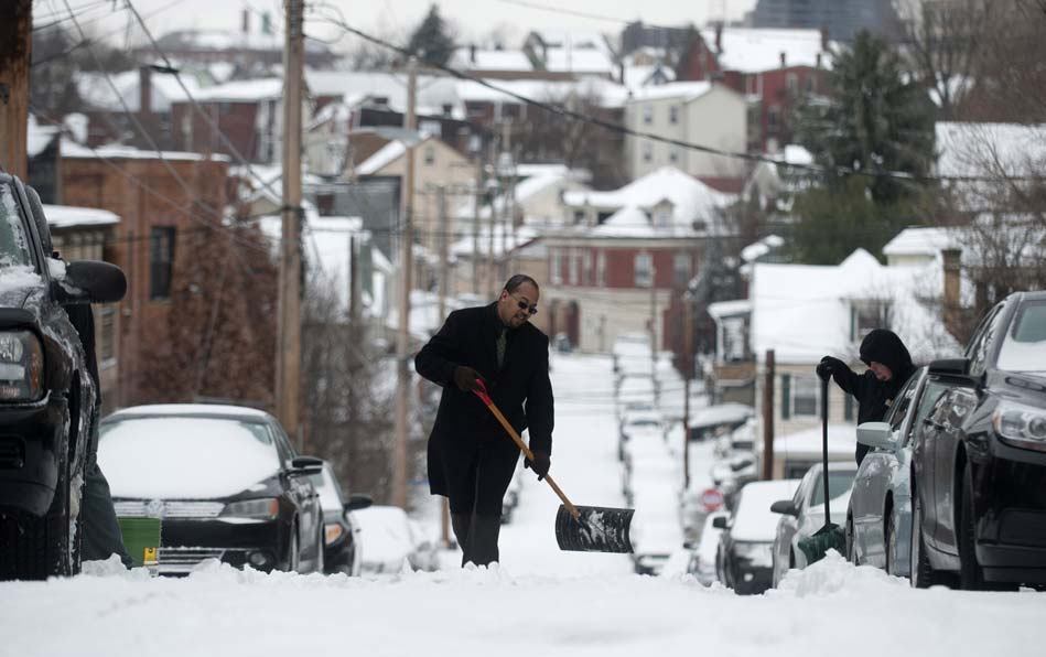 Homens limpam
rua coberta de neve em Pittsburgh