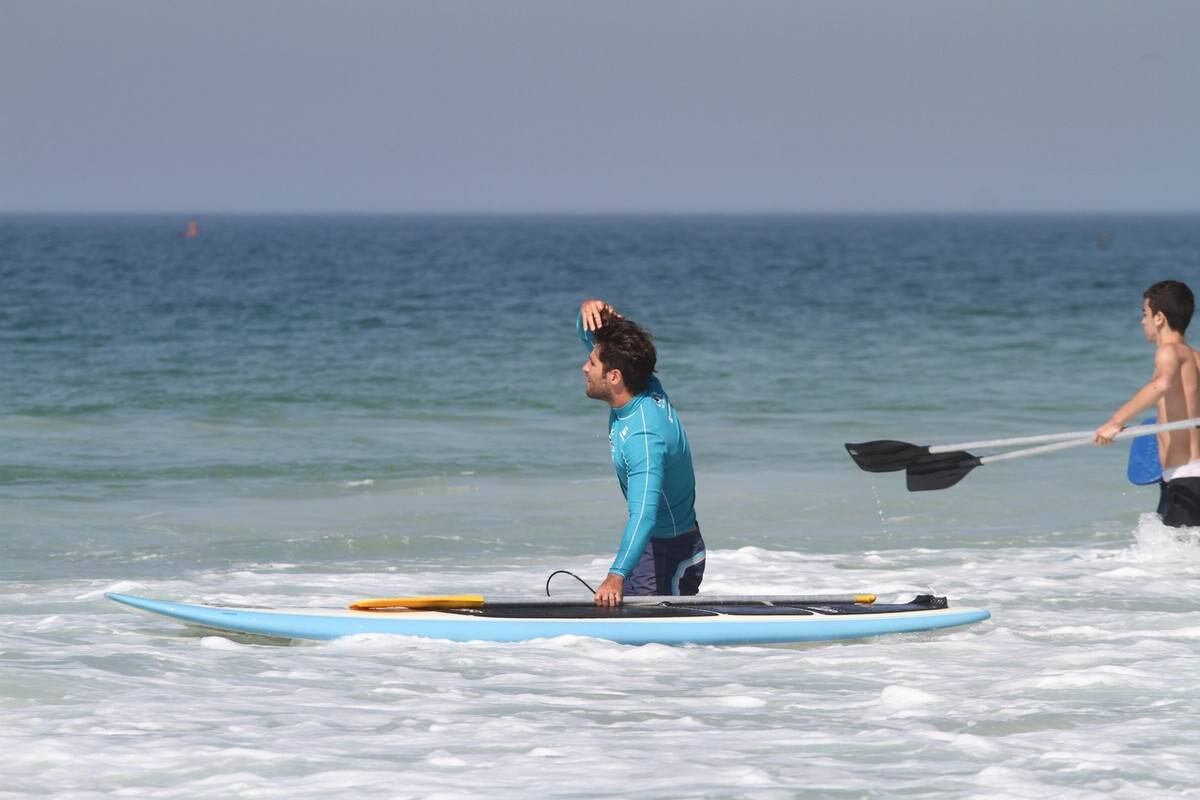 Bruno Gagliasso e Ricardo Pereira praticam stand up paddle na praia da Barra da Tijuca, no Rio