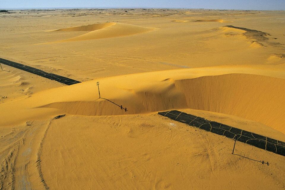 Os
grãos de areia, deslocados pelos ventos do
deserto, acumulam-se diante do menor obstáculo, como a estrada acima, no Vale do Nilo, no Egito, formando dunas.

Na história do planeta, os desertos sempre existiram. Há
centenas de milhões de anos, eles evoluíram constantemente, de acordo
com as mudanças climáticas e a deriva dos continentes. Hoje, as atividades humanas, como a exploração excessiva
da vegetação das terras semiáridas, também contribuem para a
desertificação