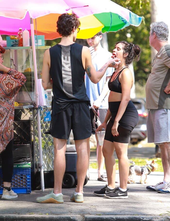 Após a caminhada, o casal parou para comer frutas frescas de um quiosque do parque