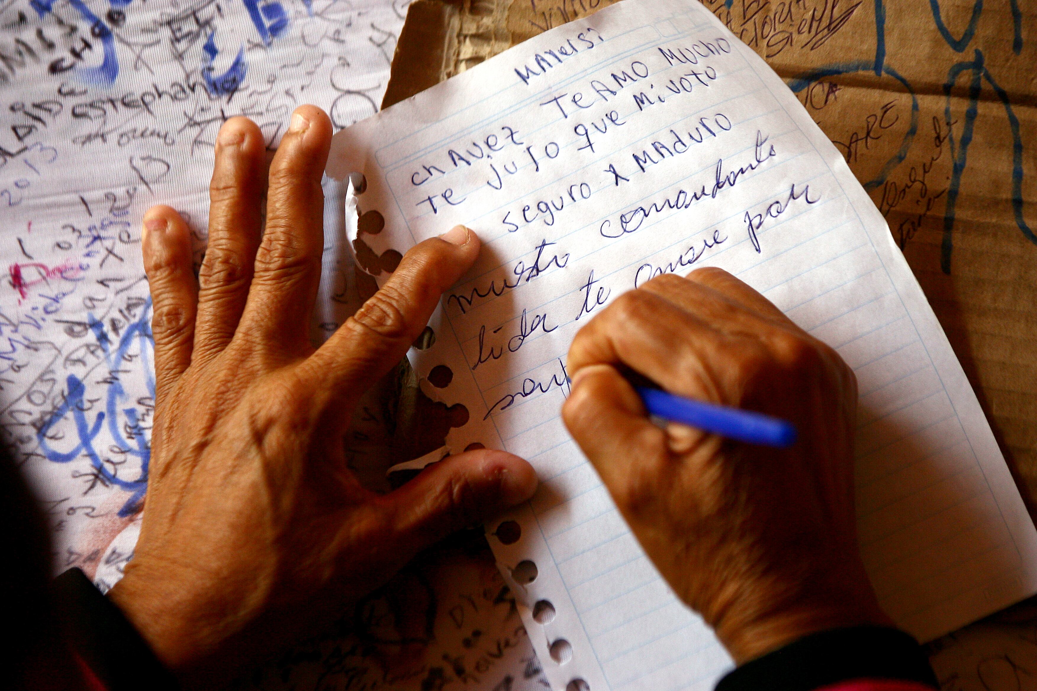 Simpatizante de Hugo Chávez deixa mensagem ao presidente morto na última terça-feira (5), na Academia Militar, em Caracas