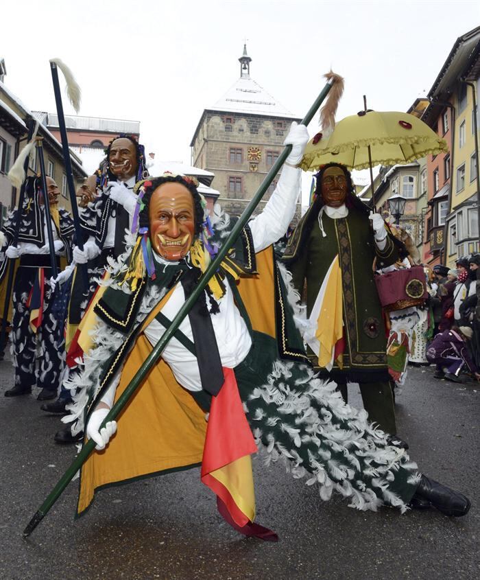 Um grupo de pessoas vestidas com fantasias vão às ruas para celebrar o Carnaval de Rottweil, na Alemanha