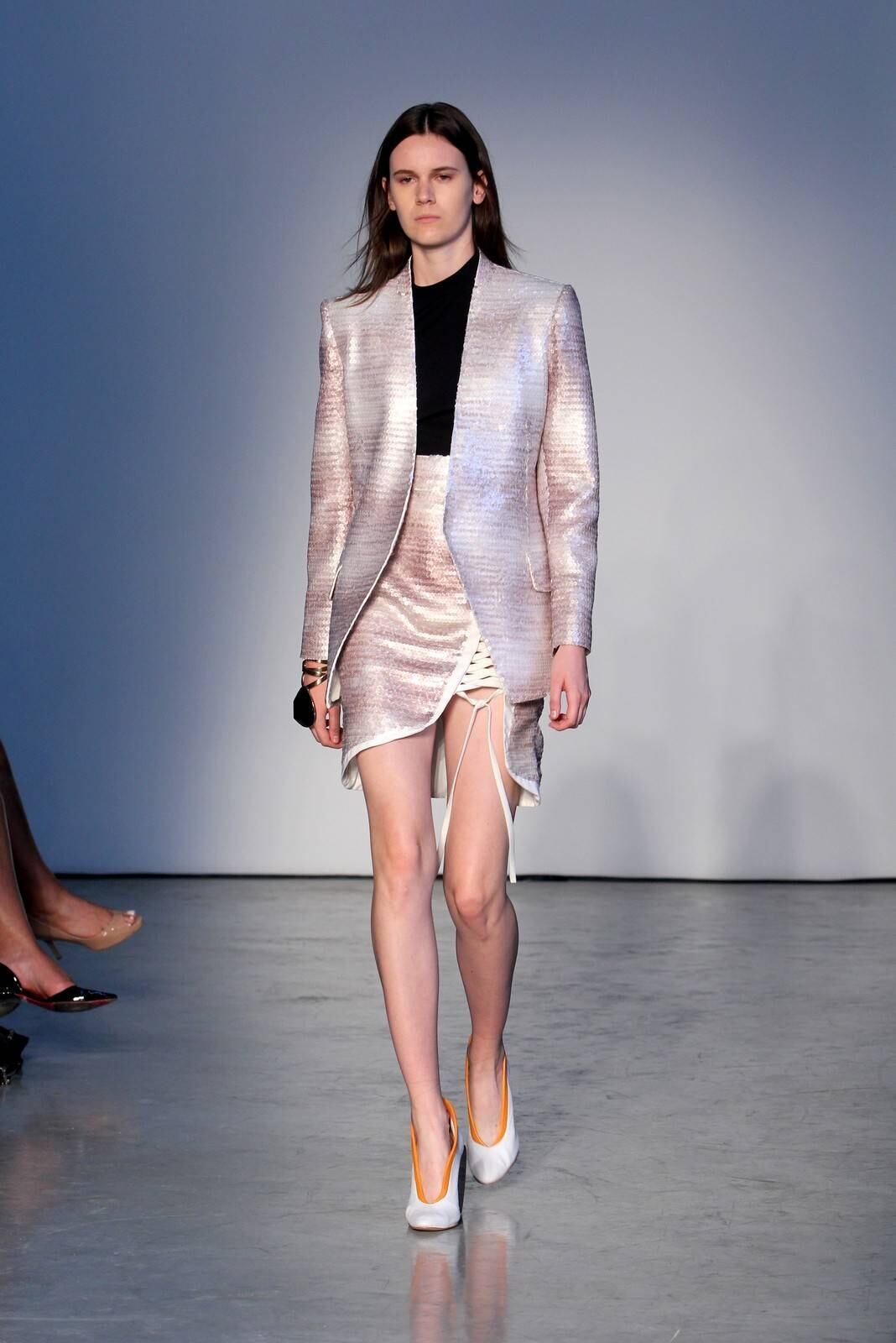 O segundo dia de desfiles da temporada inverno 2015 da São Paulo Fashion Week começou com a coleção do estilista Pedro Lourenço, nesta terça-feira (4). As modelos entraram na passarela após uma hora de atraso e vestiram peças feitas de diferentes materiais, que iam desde os trabalhos com paetês até detalhes com argolas de meta. Além dos casacos e saias que deram um ar sexy à coleção, as sandálias com saltos largos, arredondados e amarrações no tornozelo também foram destaque na passarela