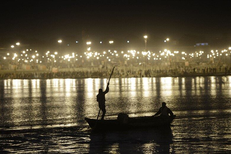 Dois homens atravessam o encontro dos rios
Yomuna e Ganges, durante o festival de Maha Kumbh festival na Índia