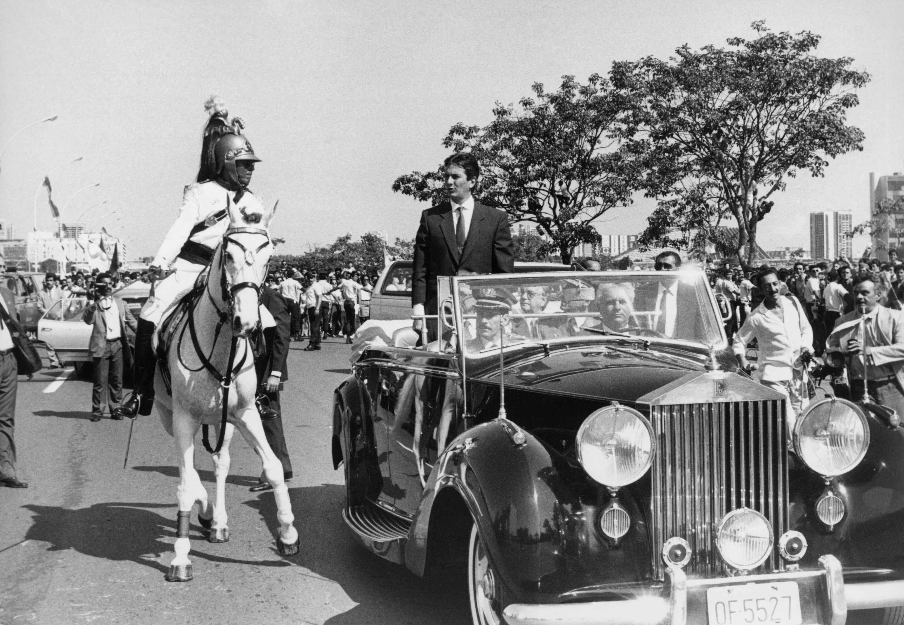 Fernando Collor de Mello (em pé ao centro) desfila em carro aberto durante a cerimônia de posse