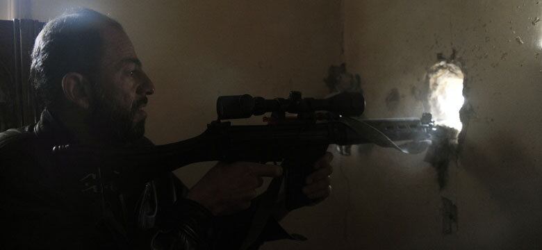 Rebelde sírio atira contra as tropas de Bashar al-Assad durante um confronto em Aleppo, neste sábado (16)