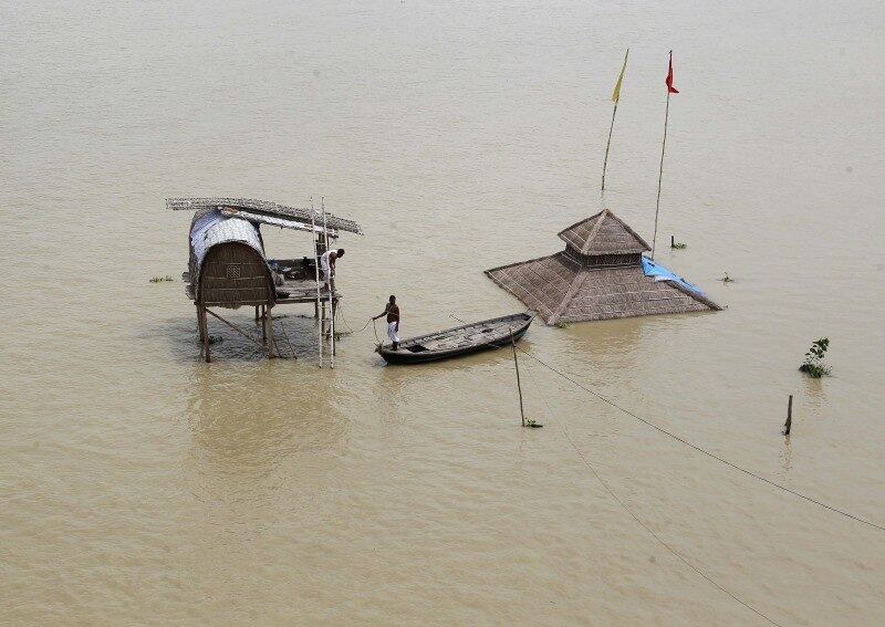 Homem senta em barco perto
de cabana submersa após as enchentes causadas pelo rio Ganga devido às fortes
chuvas de monções em Allahabad, na Índia