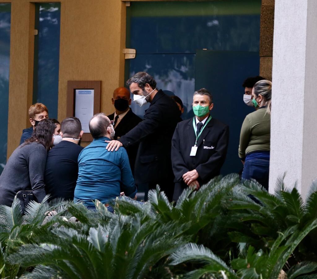 Orlando Lima Cardoso, filho do ator que aparece sentado na foto acima, foi consolado por amigos e parentes