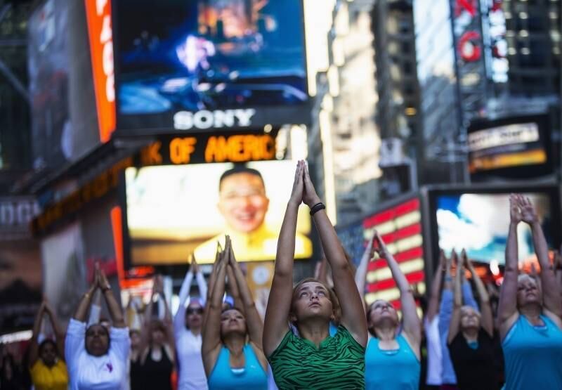 Pessoas fazem yoga na Times
Square, em Nova York, para comemorar o solstício de verão