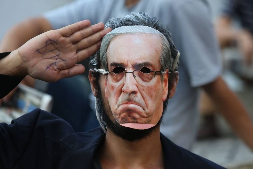 O grupo seguiu até a frente do prédio onde fica o escritório de Eduardo Cunha, no centro do Rio, e jogou para o alto notas de dinheiro com a imagem do político