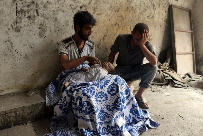 Dois homens lamentam a morte de um bebê depois de um bombardeio no bairro de al-Marja, em Aleppo, na Síria. Em setembro de 2016, as áreas da cidade ocupadas por rebeldes foram atingidas por mísseis, que causaram mortes e destruição em massa