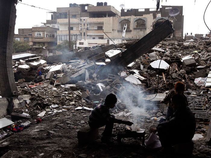 

Meninos palestinos tentam se aquecer com uma fogueira dentro
de uma casa destruída por um ataque aéreo israelense em Jabalya, região norte
da Faixa de Gaza

