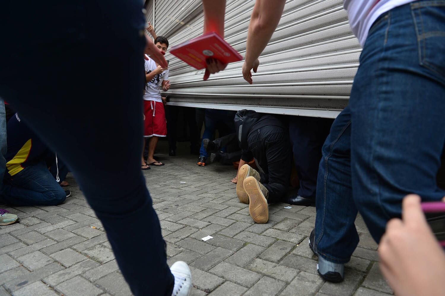 Alguns deles passaram por baixo dos portões. A quantidade de estudantes atrasados fez com que o portão ficasse entortado, não encostando completamente no chão ao final do fechamento