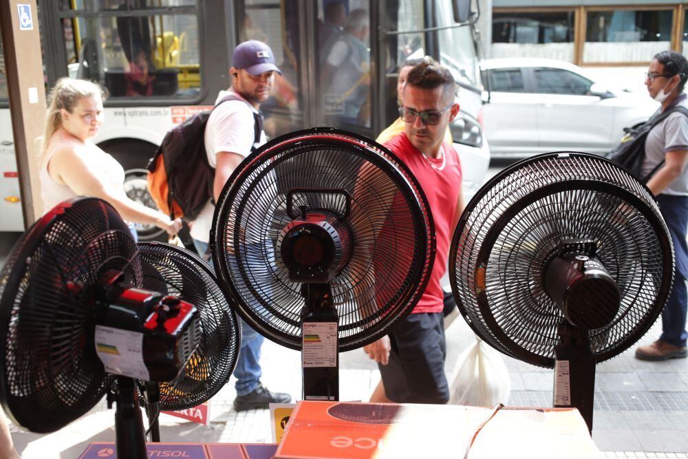 Consumidores em busca de ventiladores e produtos que amenizam o calor nas lojas do entorno da 25 de Março, na região central de São Paulo, na tarde de ontem, 14 de novembro de 2023