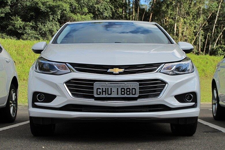 No design, o Cruze troca as linhas mais clássicas e robustas por um desenho mais esportivo e fluido, com faróis afilados e integrados à grade estreita. Vincos no para-choques realçam a enorme tomada de ar frontal e a seção dos faróis de neblina, que simulam asas aerodinâmicas — como nos monopostos da Fórmula 1