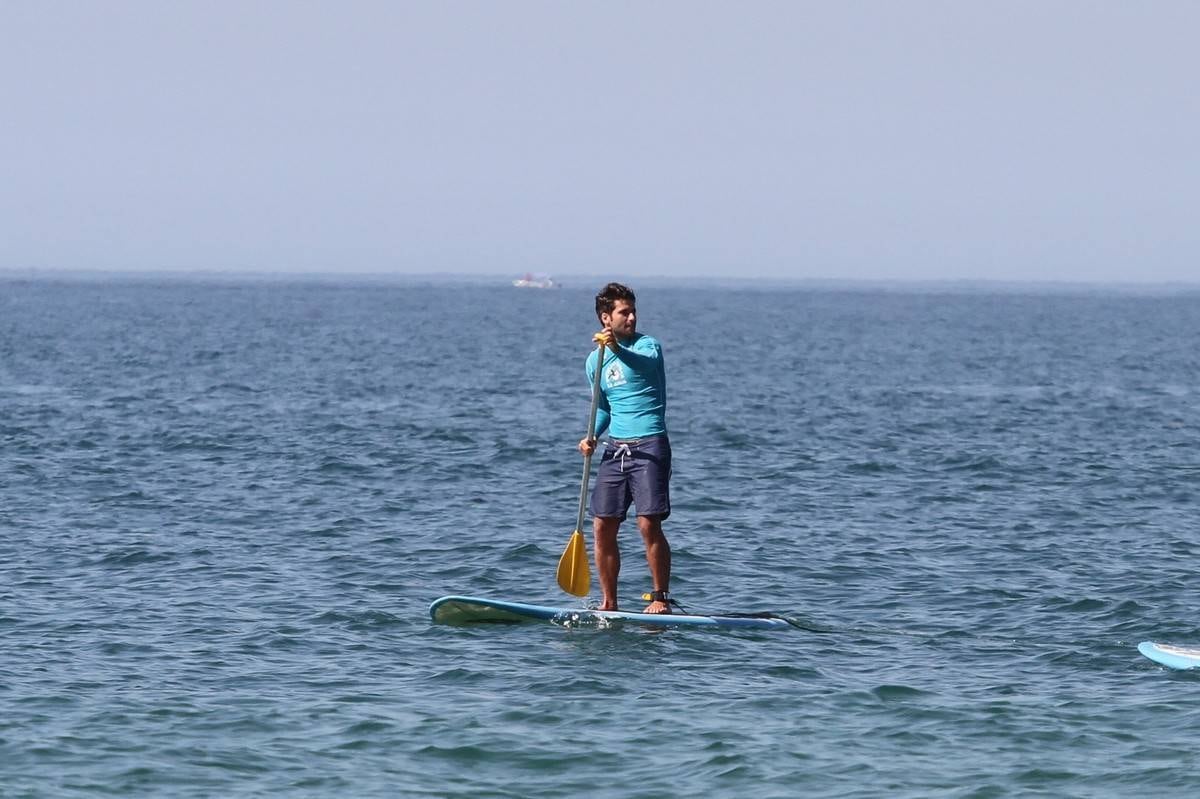 Bruno Gagliasso e Ricardo Pereira praticam stand up paddle na praia da Barra da Tijuca, no Rio