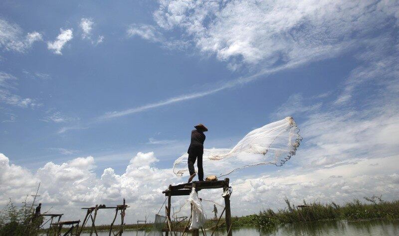 Pescador joga sua rede em lago
próximo a Phnom Penh, no Camboja