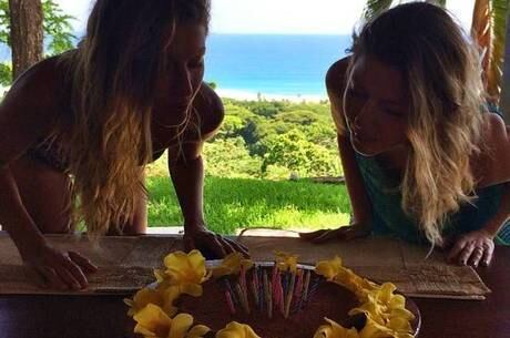 Velas coloridas e bolo com flores para os 34 anos das gêmeas Bündchen