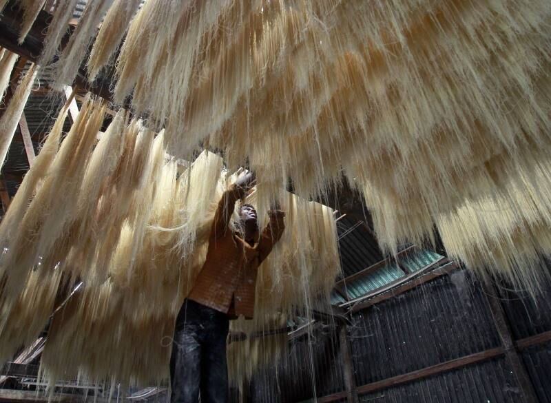 Funcionário de fábrica
indiana em Agartala coloca para secar tiras de vermicelli, uma espécie de massa
tipicamente consumida durante o mês do Ramadã na Índia