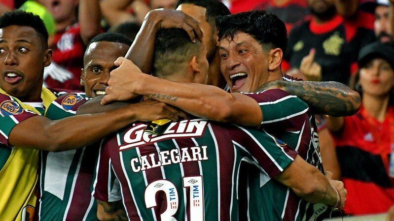 Fim do jejum! Após dez anos, o Fluminense voltou a levantar a taça do Campeonato Carioca. O time empatou a segunda partida com o Flamengo, mas tinha garantido a vantagem no jogo de ida, pois venceu o Rubro-Negro por 2 a 0. Relembre todos os títulos estaduais do Tricolor das Laranjeiras!