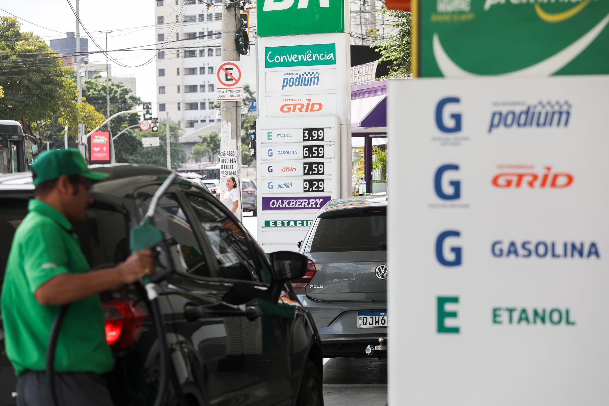 Frentista trabalha em posto de combustível com carro parado