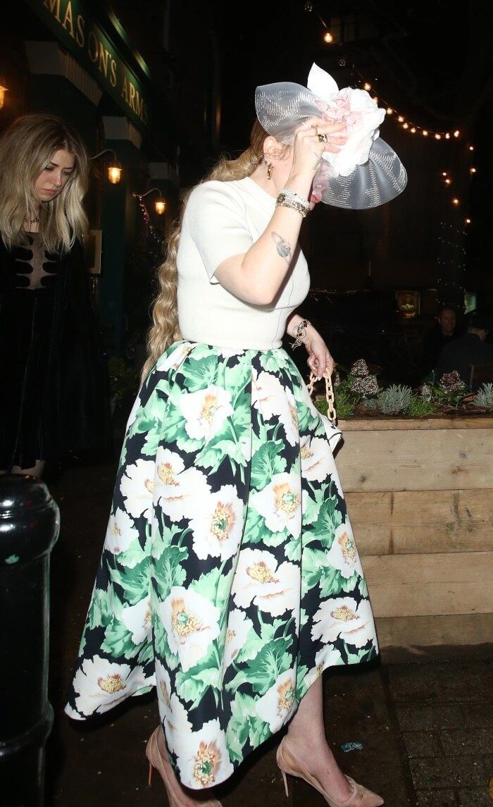 Ao deixar o local do evento em Londres, na Inglaterra, Adele escondeu o rosto para evitar os flashes 