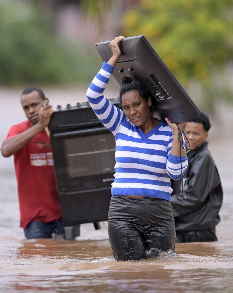 People wade through the water as they remove belongings from their homes in the flooded Brazilian municipality of Juatuba, located in the state of Minas Gerais, on January 10, 2022, after extremely heavy rain has fallen in recent days in the southeastern part of the country.
Douglas MAGNO / AFP
