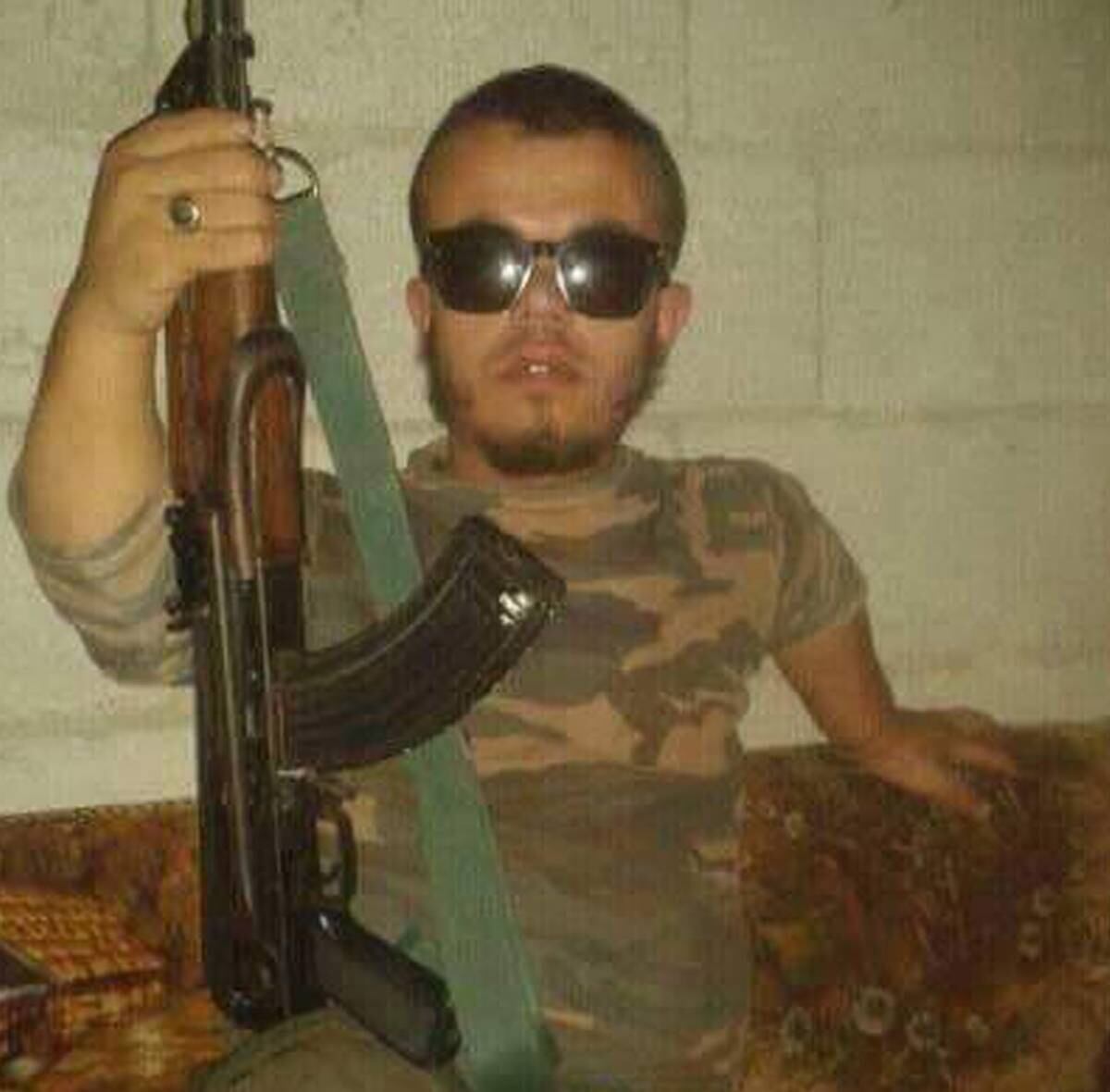 Imagens publicadas na internet mostram o extremista, cujo grupo luta contra o regime sírio e o Estado Islâmico, armado com seu rifle, uniforme camuflado e um cinto de munição, ao lado de um caminhão. Em outra foto, ele aparece de óculos de sol, enquanto segura a arma em uma das mãos