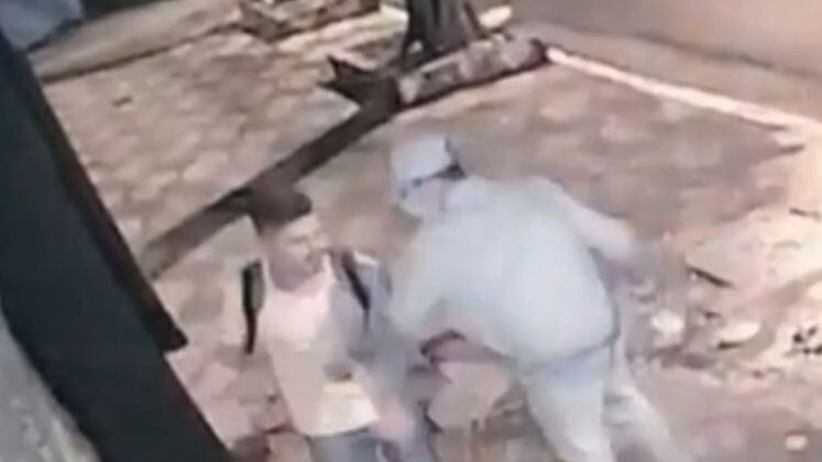 Em seguida, Lucas atravessa a rua e se aproxima do portão de uma casa. Quando ele tenta colocar a chave na fechadura, Marcos aparece com uma faca e inicia o ataque