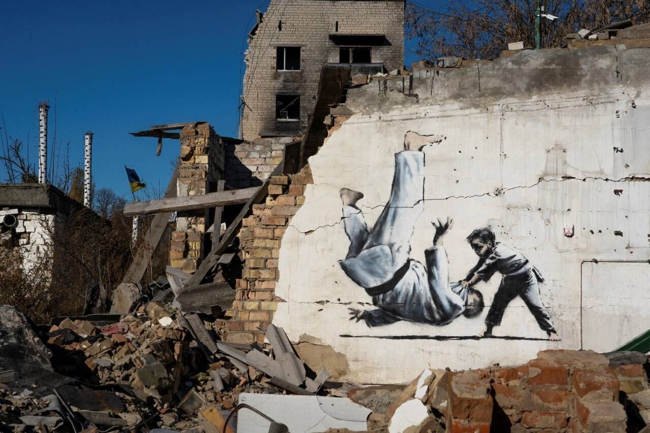 Outra obra em Borodianka, cuja autoria não foi reivindicada por Banksy, mostra um menino que joga no chão um homem com uniforme de judô. A cena pode ser uma referência ao presidente russo, Vladimir Putin, apaixonado por artes marciais
