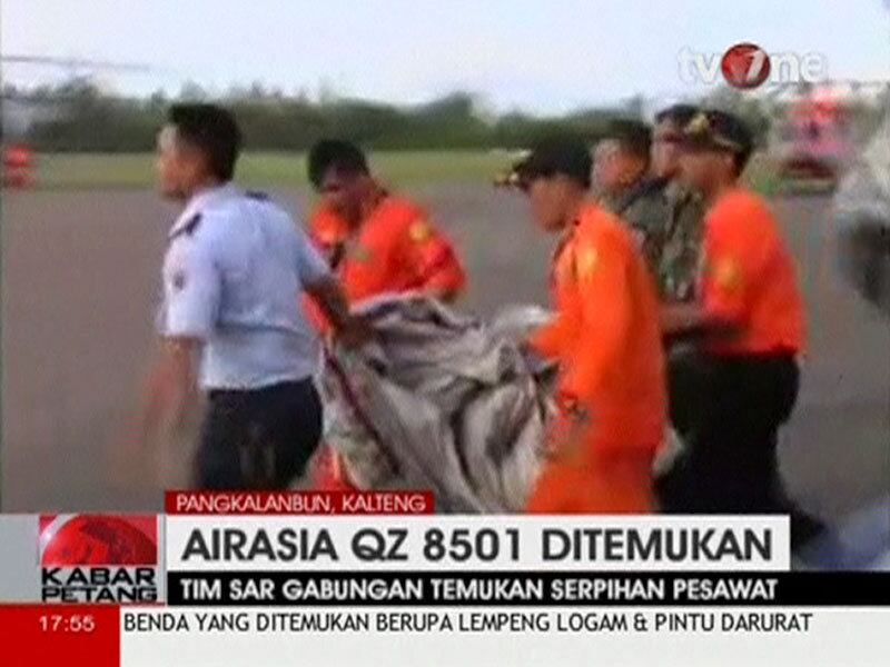 Membros das equipes de resgate carregam destroços do avião da AirAsia que caiu no mar de Java. Ao menos 40 corpos já foram retirados do mar