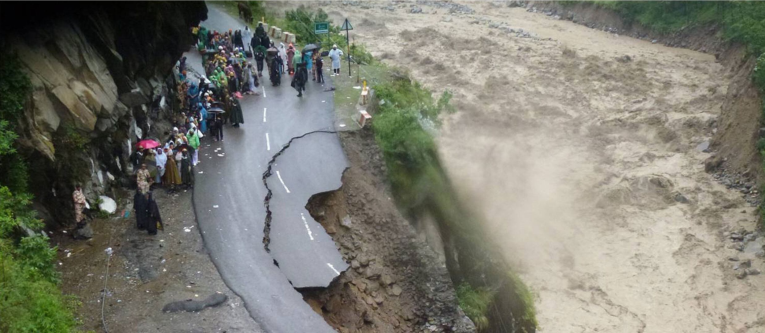 Serviços de segurança e moradores observam a destruição de uma estrada ao longo do rio Alaknanda, em Uttarakhand